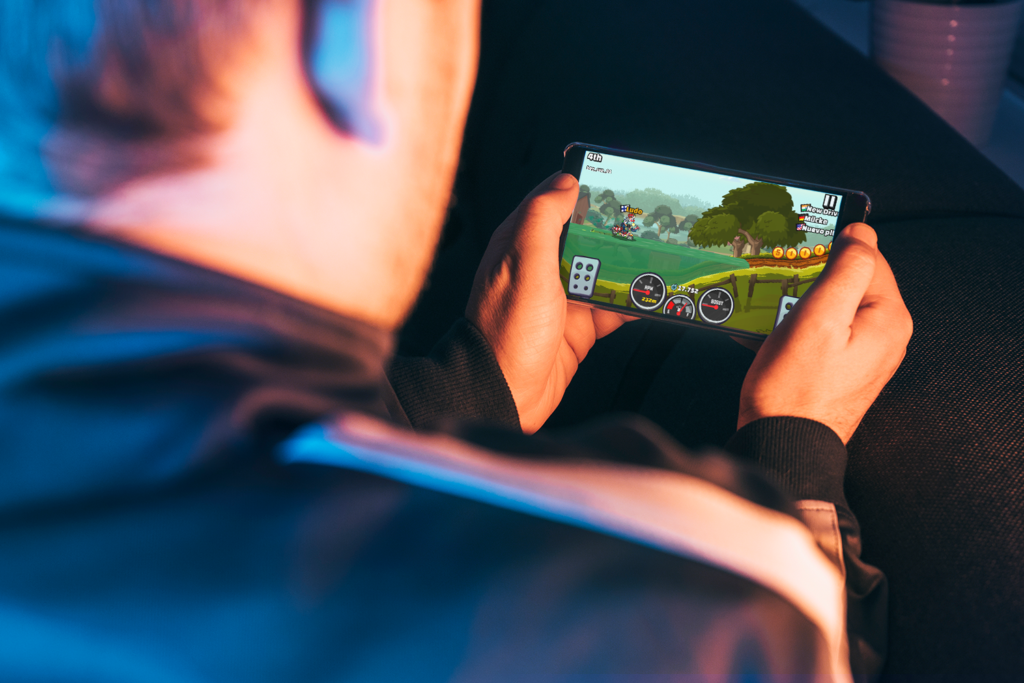 Kid playing Hill Climb Racing on phone