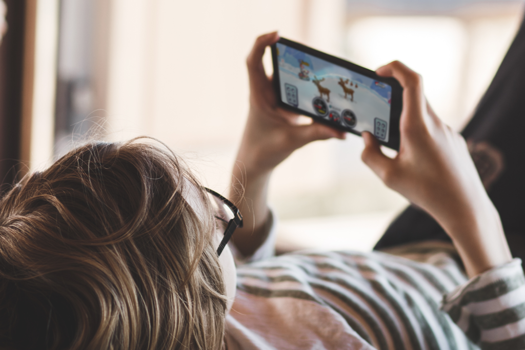 Kid playing Hill Climb Racing on phone
